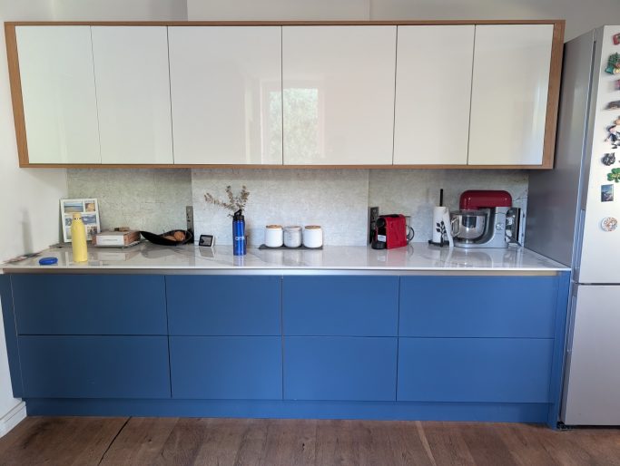 Custom blue and white fitted kitchen with oak trim