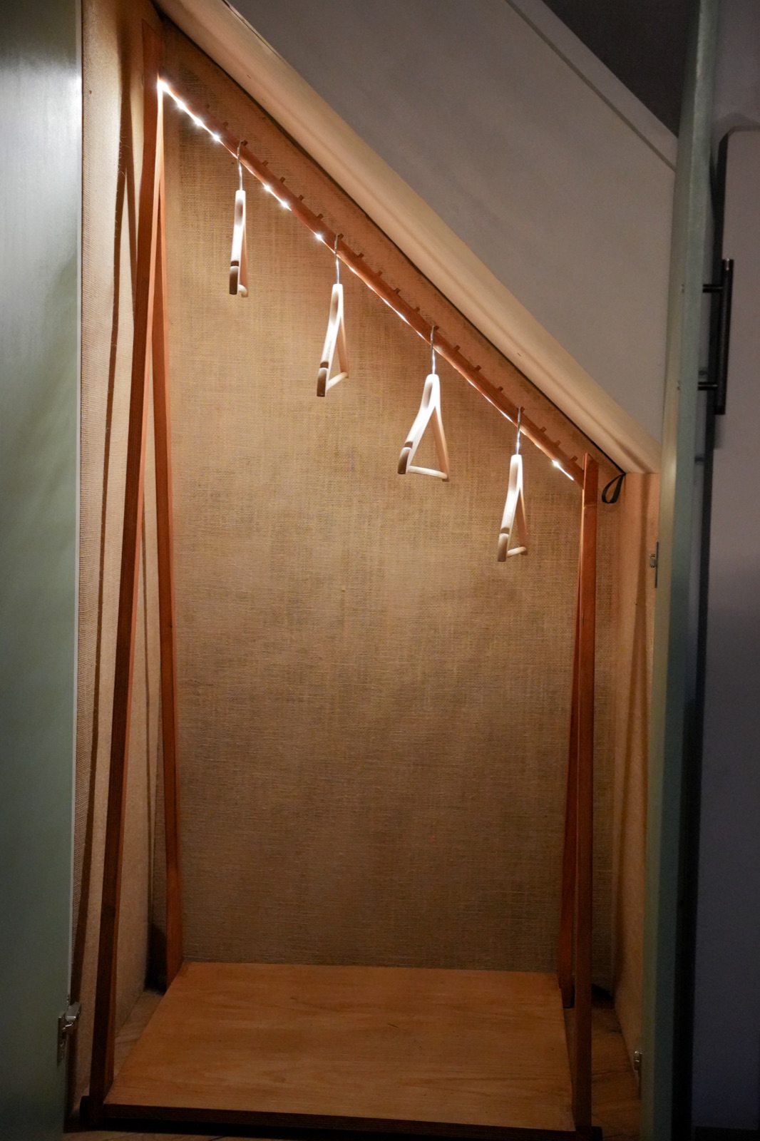 Under-stair wardrobe with LED strip lighting and hanging rail